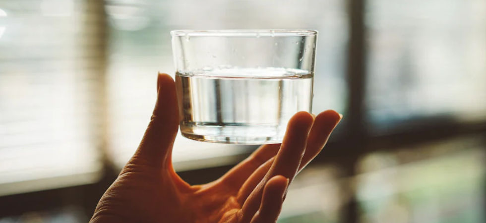 stock photo of a hand holding a glass of water.